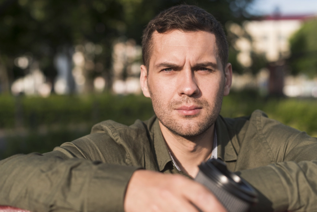 portrait-serious-young-man-looking-camera-park