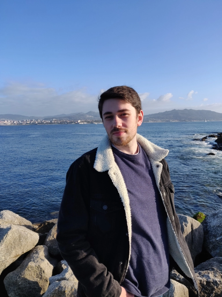 portrait-young-man-standing-sea-against-sky