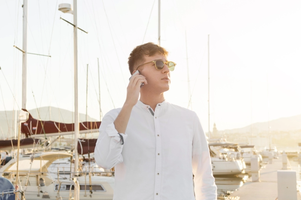 front-view-man-talking-phone-outdoors-marina